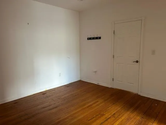 Unfurnished 2nd Office featuring wood floors and a door Unfurnished 2nd Office featuring wood floors and a door