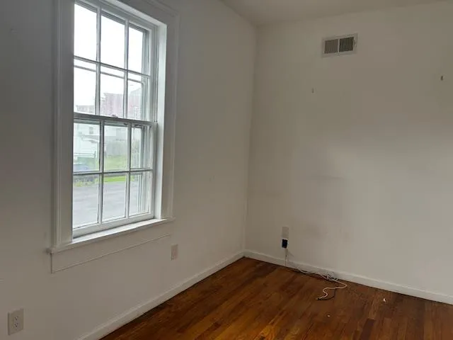 Unfurnished Office featuring wood floors and a window with natural light Unfurnished Office featuring wood floors and a window with natural light