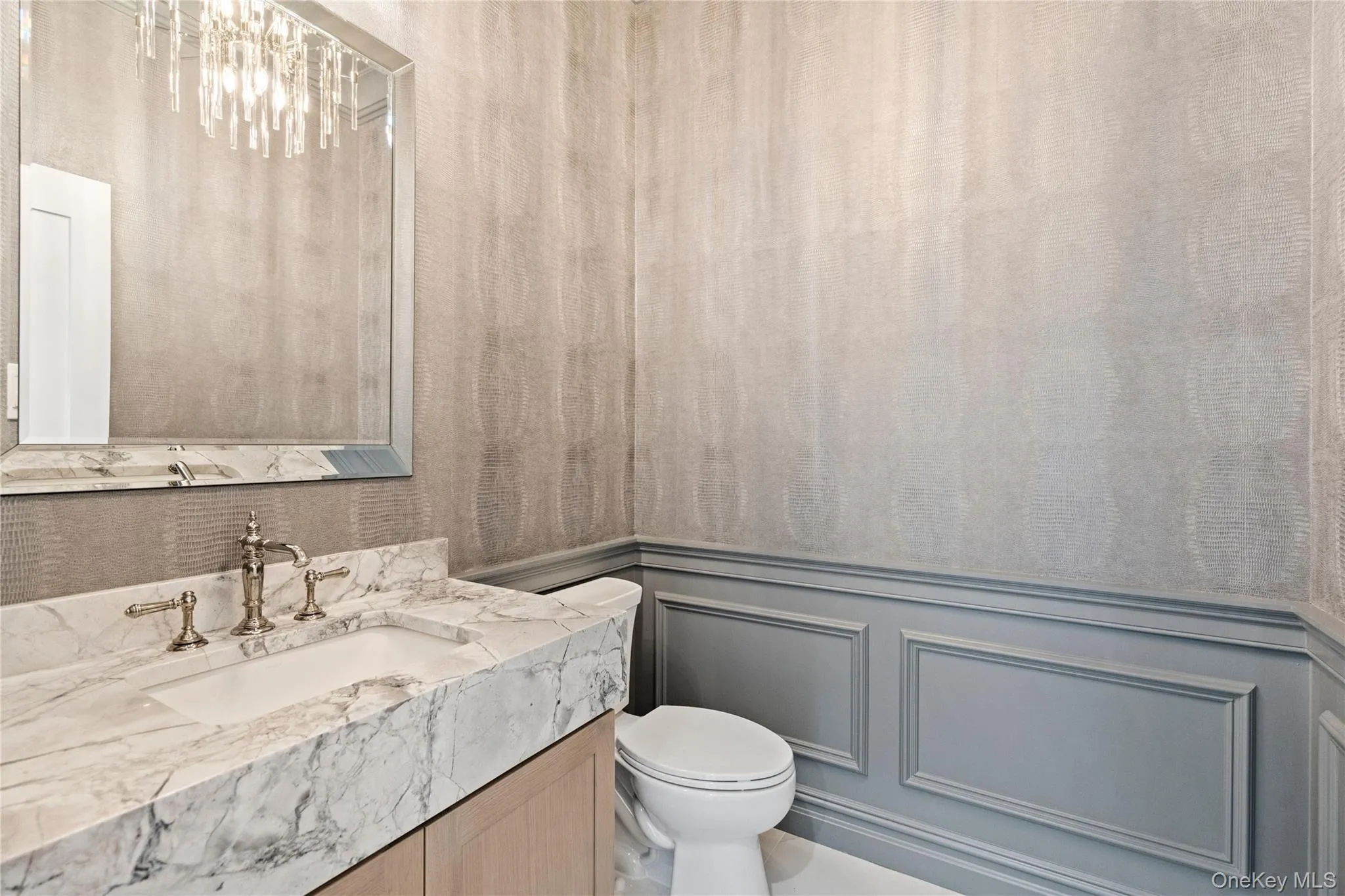 Bathroom with a decorative wall, wainscoting, and vanity Bathroom with a decorative wall, wainscoting, and vanity