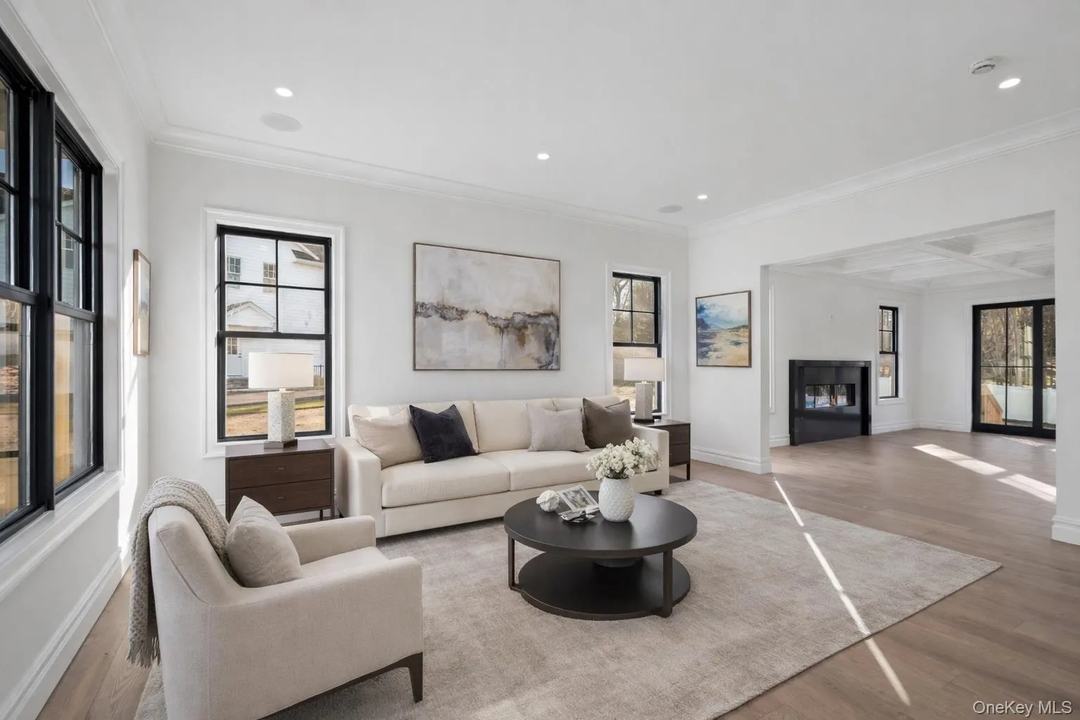 Living room with wood finished floors, a fireplace, recessed lighting, crown molding, and coffered ceiling Living room with wood finished floors, a fireplace, recessed lighting, crown molding, and coffered ceiling