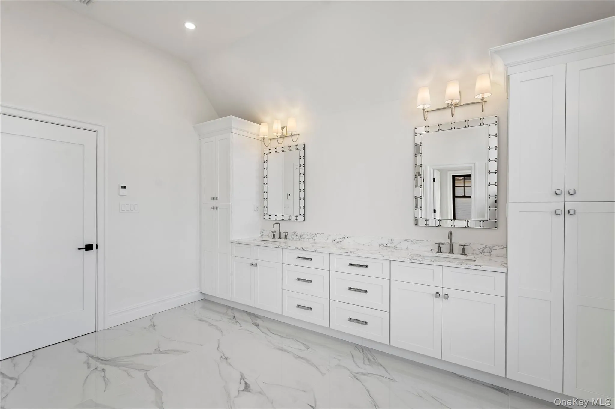 Bathroom featuring light marble finish flooring, double vanity, vaulted ceiling, and recessed lighting Bathroom featuring light marble finish flooring, double vanity, vaulted ceiling, and recessed lighting