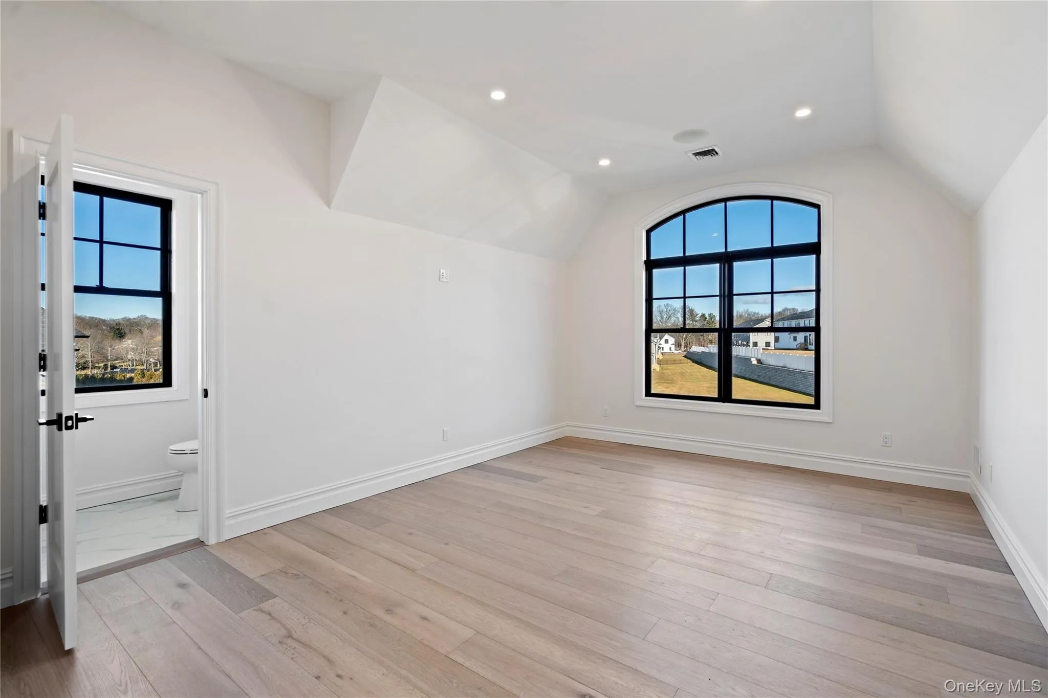 Bonus room with light wood finished floors, plenty of natural light, lofted ceiling, and recessed lighting Bonus room with light wood finished floors, plenty of natural light, lofted ceiling, and recessed lighting