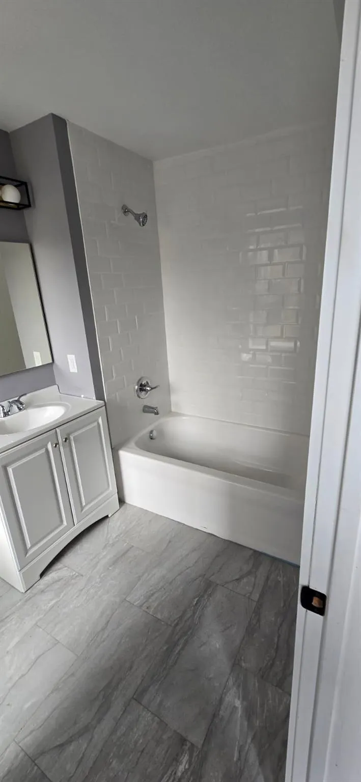 Bathroom featuring vanity, marble finish floor, and shower / bath combination Bathroom featuring vanity, marble finish floor, and shower / bath combination