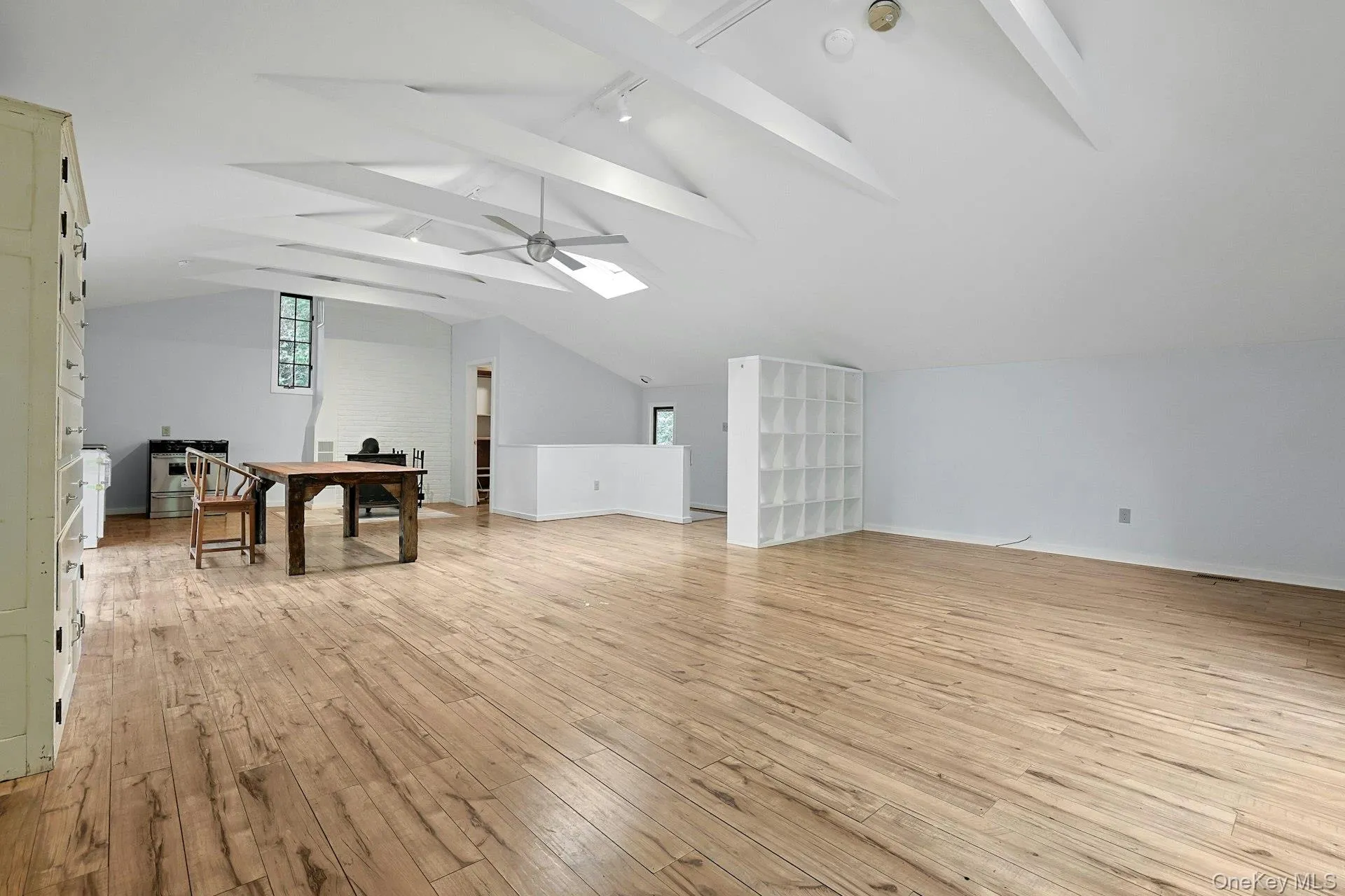 Bonus room featuring light wood-style floors, ceiling fan, a skylight, and baseboards Bonus room featuring light wood-style floors, ceiling fan, a skylight, and baseboards