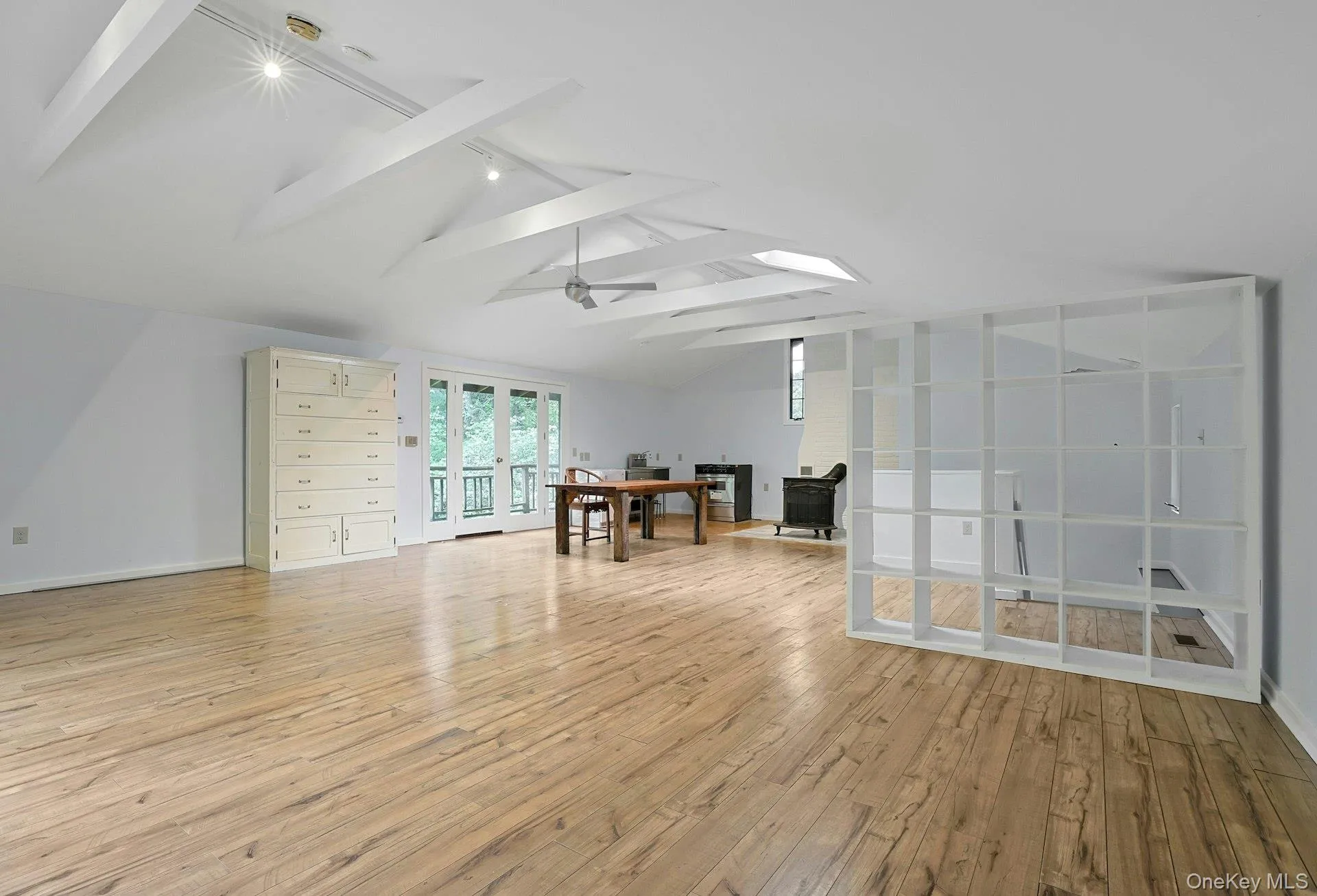 Spare room featuring rail lighting, light wood-style flooring, french doors, and baseboards Spare room featuring rail lighting, light wood-style flooring, french doors, and baseboards