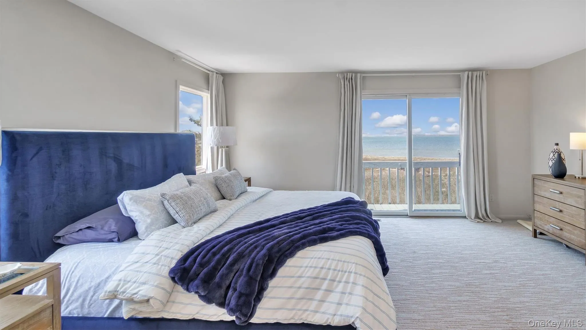 Carpeted bedroom with access to outside and a water view Carpeted bedroom with access to outside and a water view