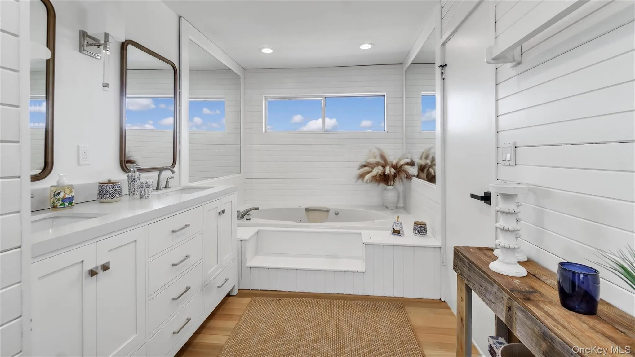 Bathroom with a sink, double vanity, recessed lighting, a bath, and wood finished floors Bathroom with a sink, double vanity, recessed lighting, a bath, and wood finished floors