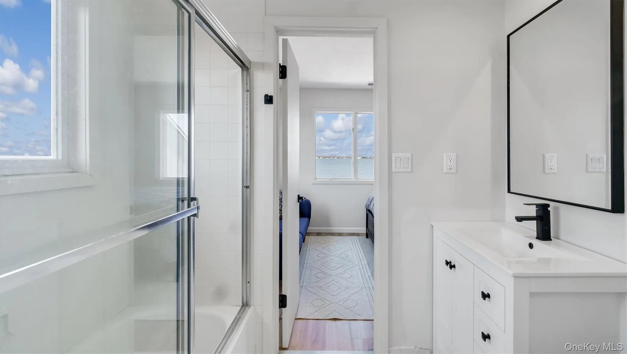 Shared Bathroom with combined bath / shower with glass door, vanity, and ensuite bathroom Shared Bathroom with combined bath / shower with glass door, vanity, and ensuite bathroom