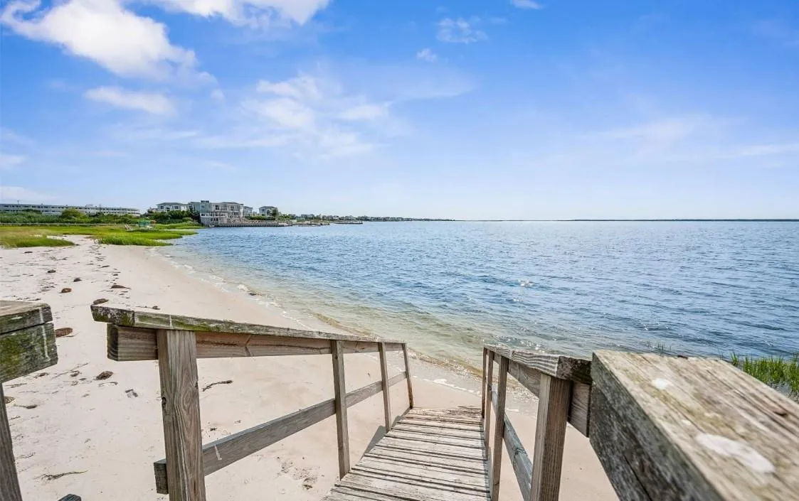 View of dock with a water view and a view of the beach View of dock with a water view and a view of the beach