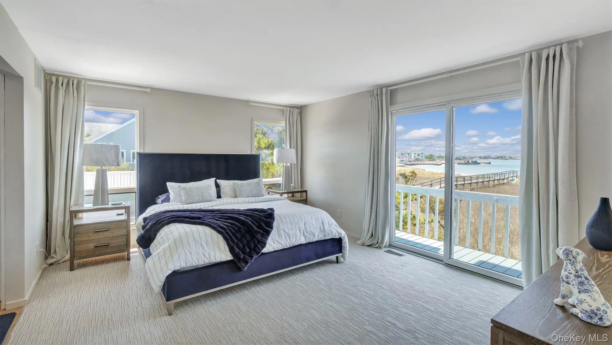 Bedroom featuring a water view, access to outside, carpet, and visible vents Bedroom featuring a water view, access to outside, carpet, and visible vents