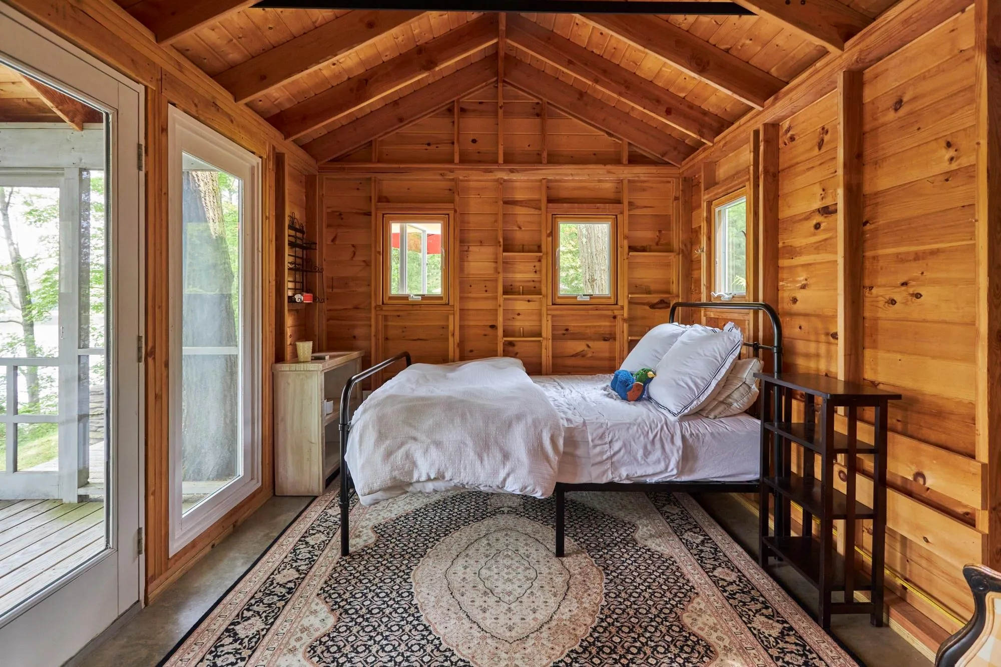 Bedroom featuring multiple windows, lofted ceiling with beams, wooden ceiling, and access to outside Bedroom featuring multiple windows, lofted ceiling with beams, wooden ceiling, and access to outside