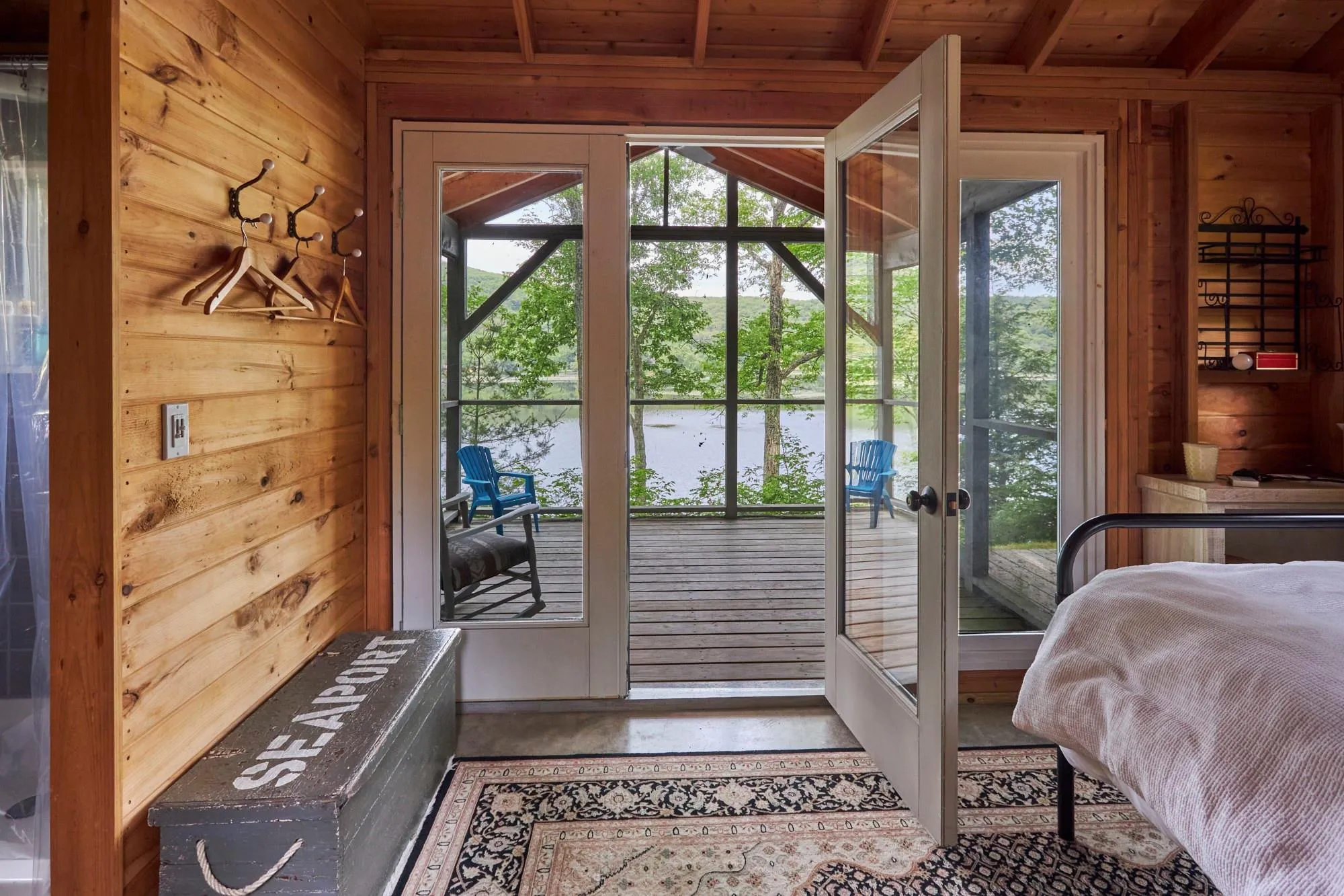 Entryway with plenty of natural light, wooden walls, a water view, and wood ceiling Entryway with plenty of natural light, wooden walls, a water view, and wood ceiling