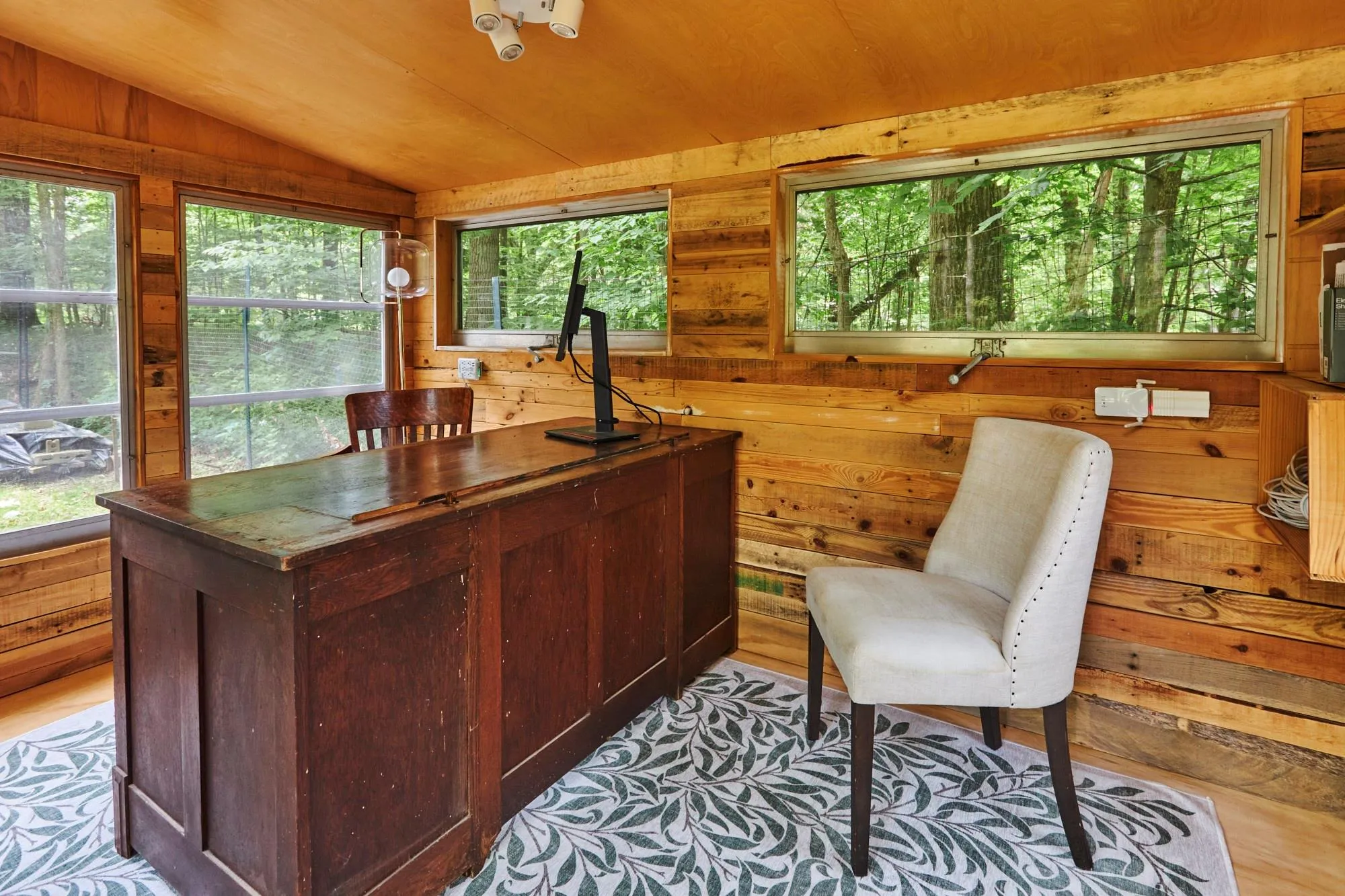 Office area featuring wood ceiling, wooden walls, and vaulted ceiling Office area featuring wood ceiling, wooden walls, and vaulted ceiling