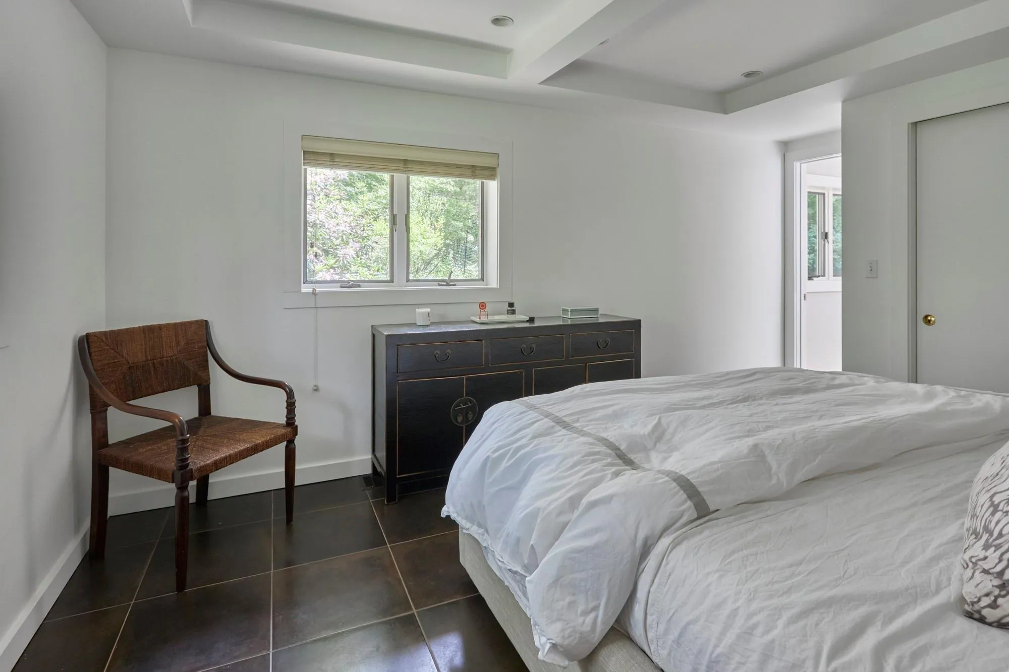 Bedroom featuring baseboards and dark tile patterned flooring Bedroom featuring baseboards and dark tile patterned flooring