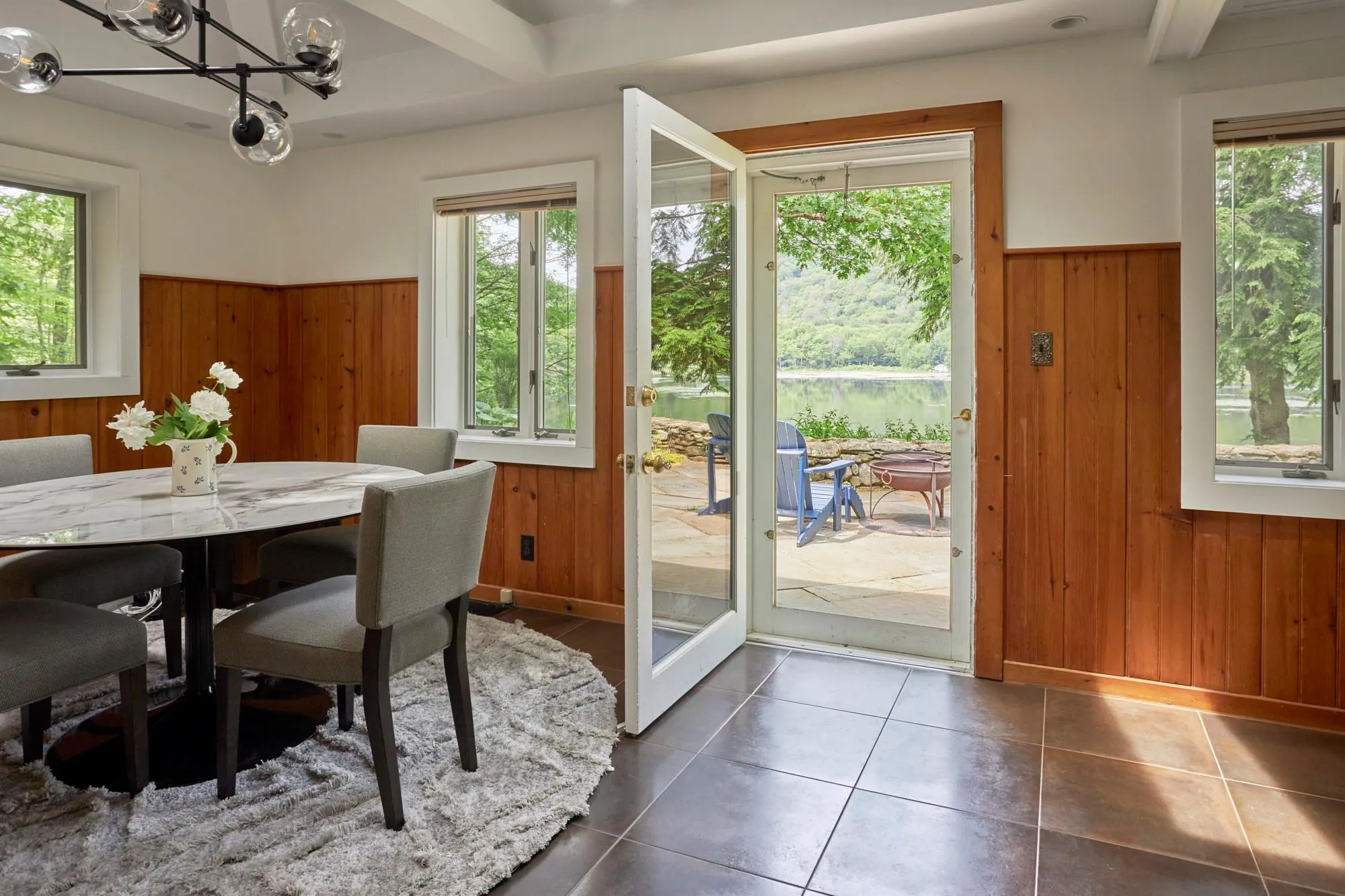 Dining space with a wainscoted wall, wood walls, and plenty of natural light Dining space with a wainscoted wall, wood walls, and plenty of natural light