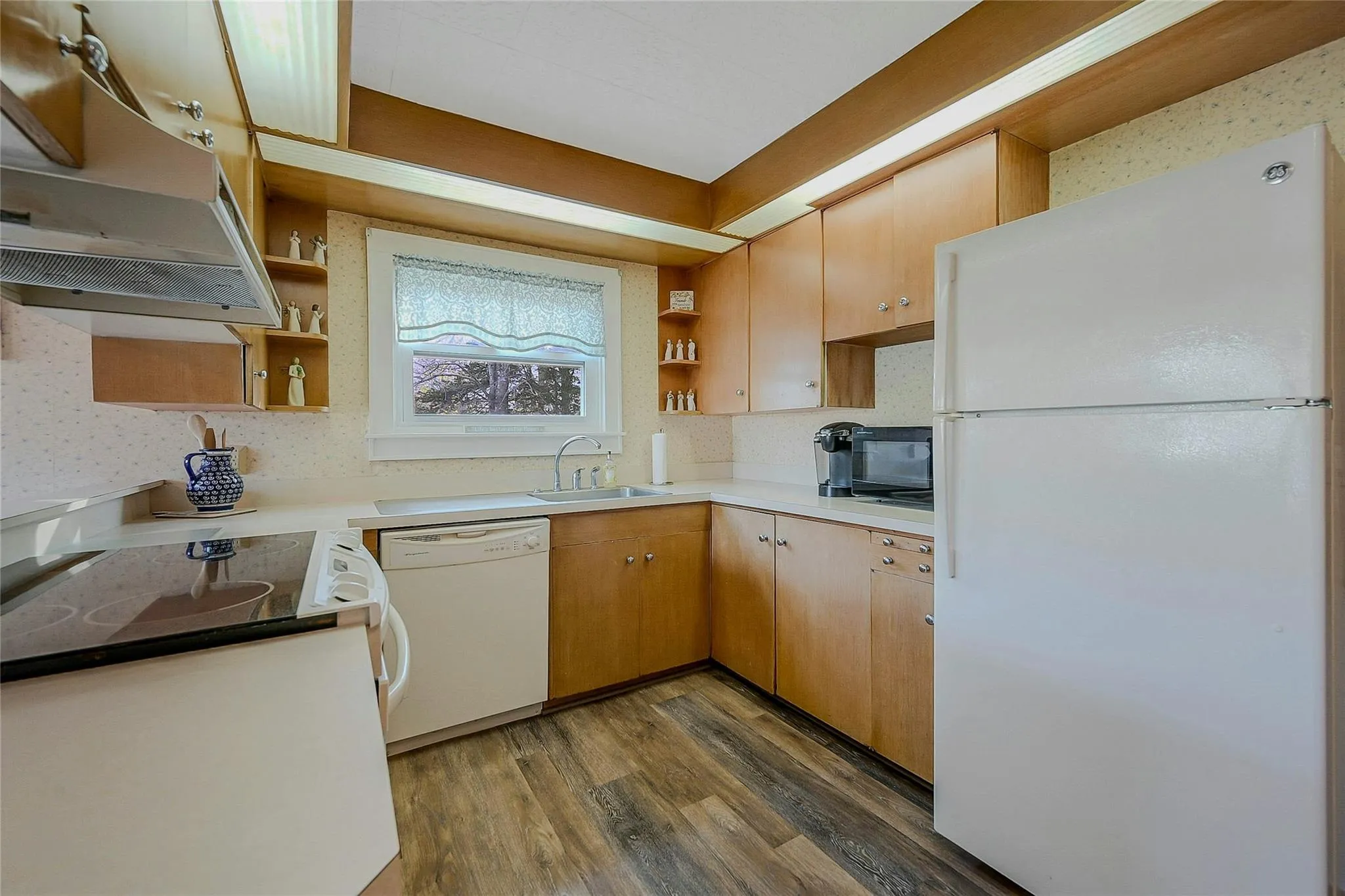 Kitchen featuring white appliances, under cabinet range hood, a sink, open shelves, and dark wood-style floors Kitchen featuring white appliances, under cabinet range hood, a sink, open shelves, and dark wood-style floors
