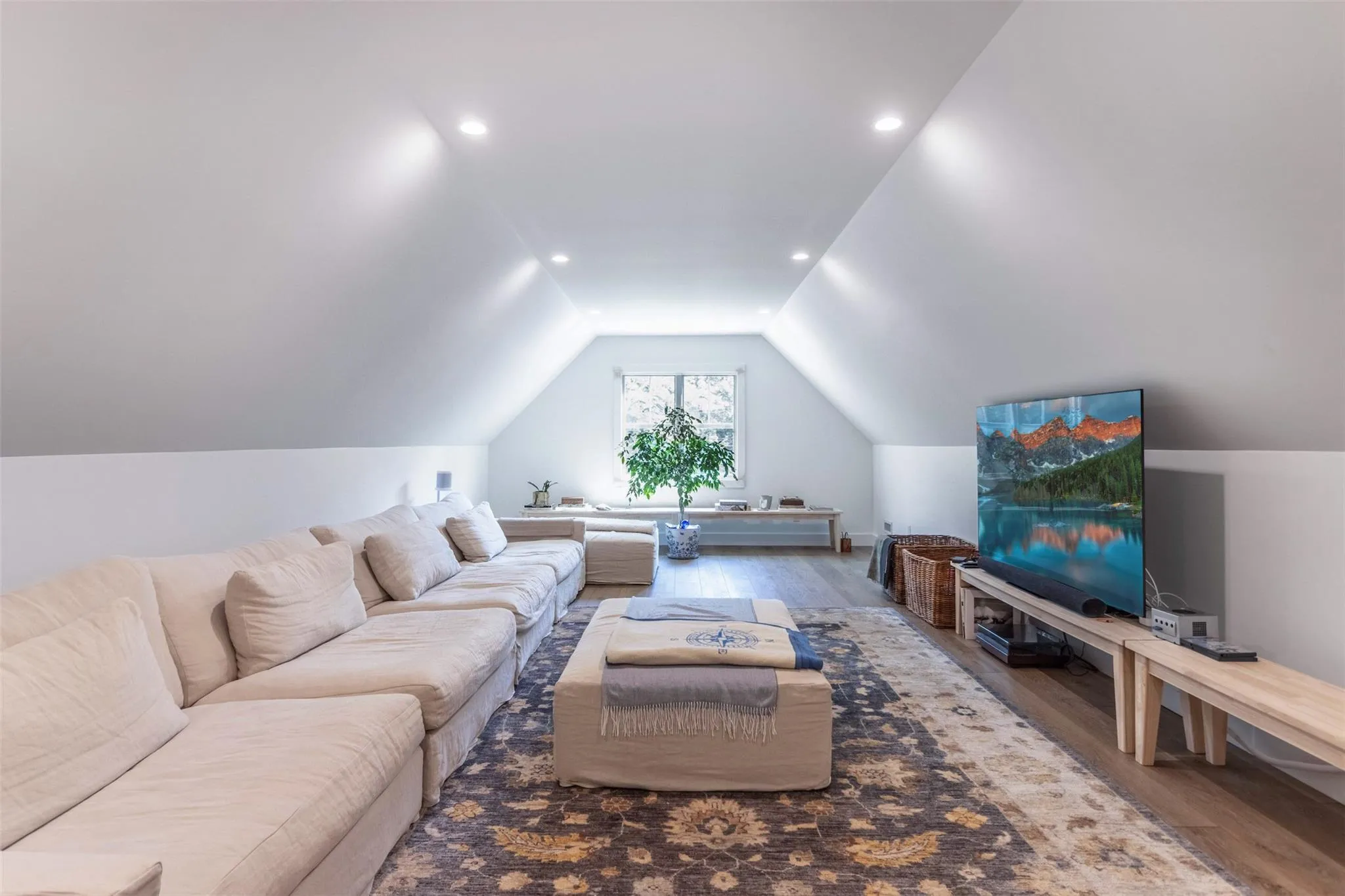 Living room with vaulted ceiling, wood finished floors, and recessed lighting Living room with vaulted ceiling, wood finished floors, and recessed lighting