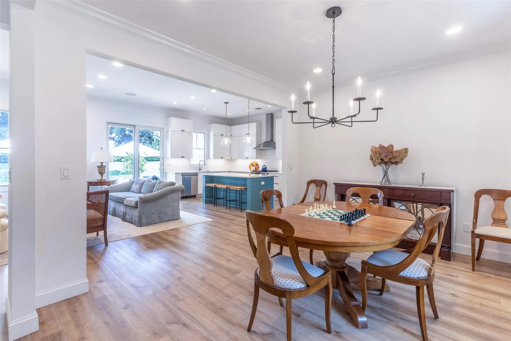 Dining area featuring ornamental molding, light wood-style floors, and a chandelier Dining area featuring ornamental molding, light wood-style floors, and a chandelier