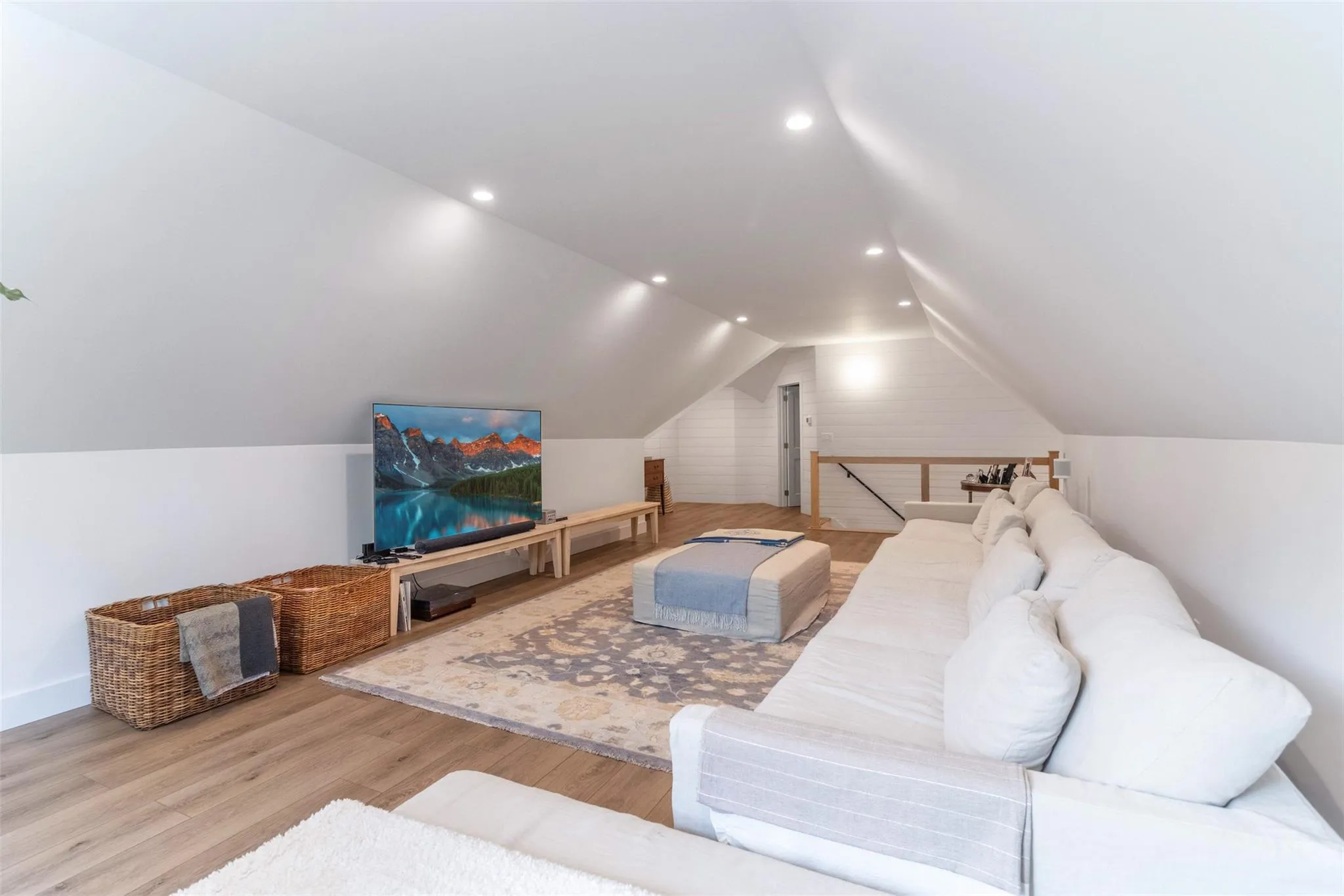 Living room featuring recessed lighting, vaulted ceiling, and wood finished floors Living room featuring recessed lighting, vaulted ceiling, and wood finished floors