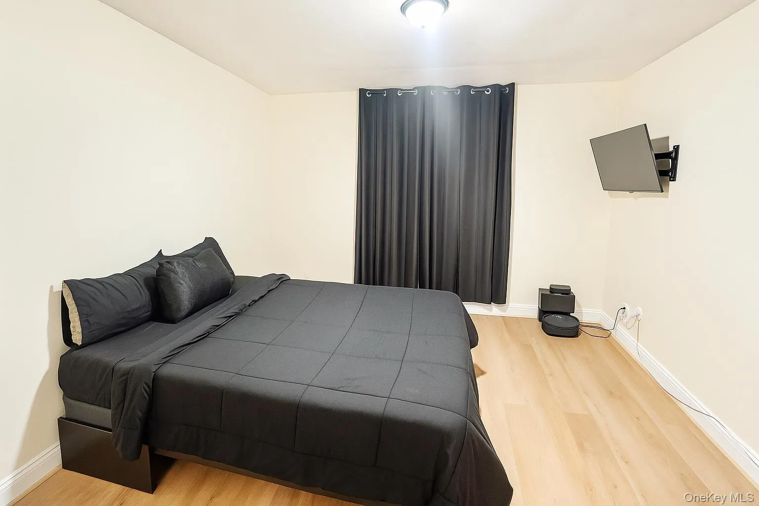 Bedroom featuring light planked finished floors and baseboards Bedroom featuring light planked finished floors and baseboards