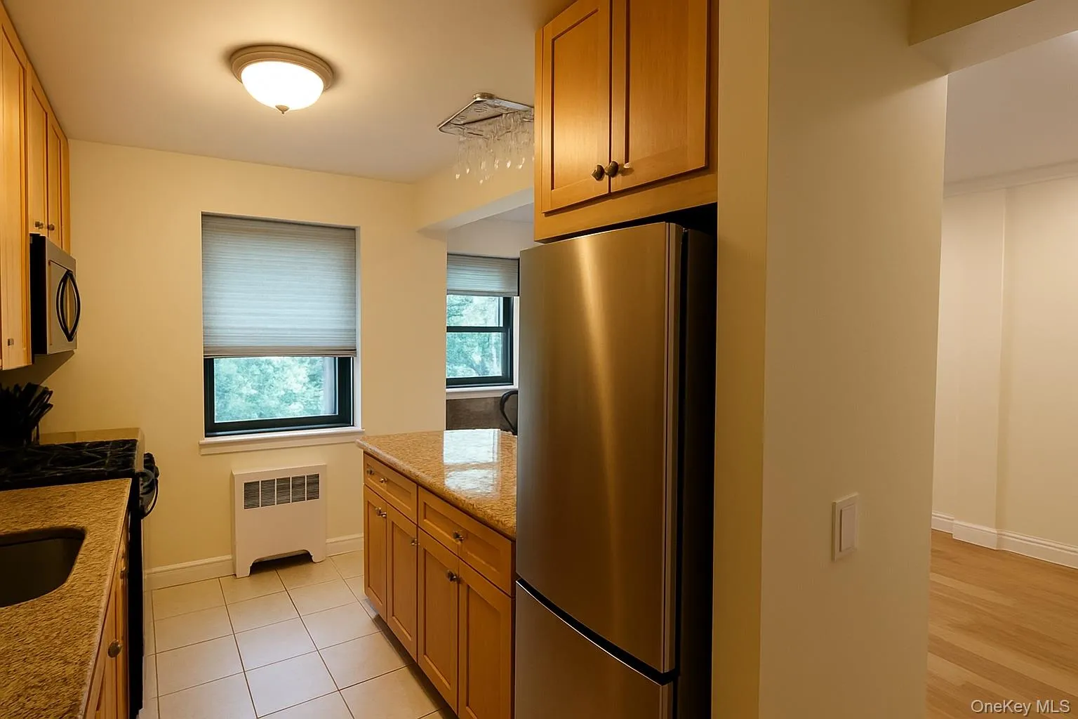 Kitchen featuring freestanding refrigerator, light stone counters, and gas stove. Kitchen featuring freestanding refrigerator, light stone counters, and gas stove.