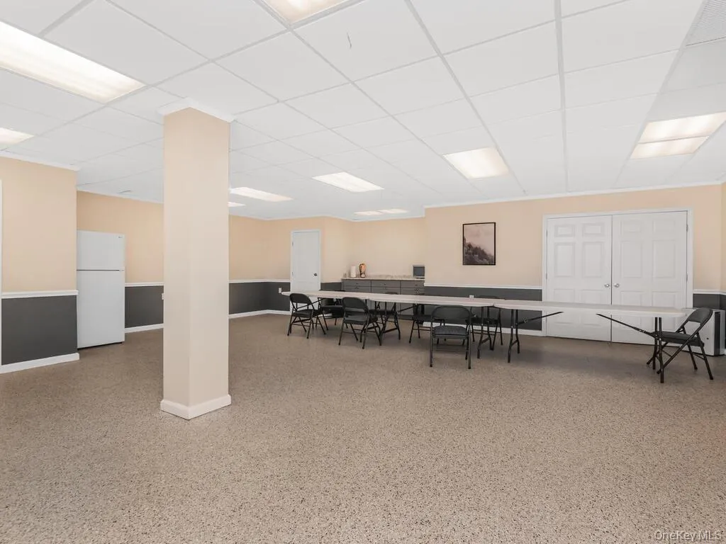 Recreation room featuring speckled floor and a paneled ceiling Recreation room featuring speckled floor and a paneled ceiling