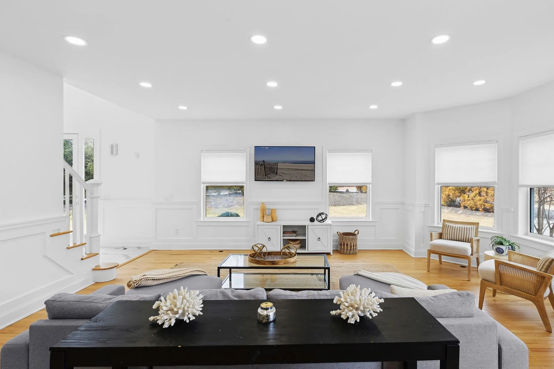 Living room featuring a wainscoted wall, recessed lighting, stairway, and light wood-type flooring Living room featuring a wainscoted wall, recessed lighting, stairway, and light wood-type flooring