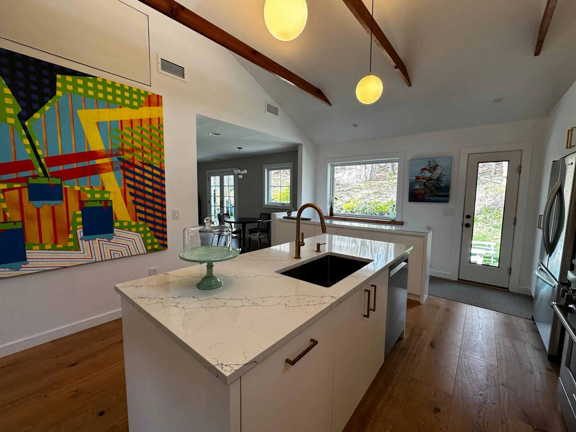 Kitchen featuring lofted ceiling with beams, visible vents, stainless steel appliances, dark wood-type flooring, and a sink Kitchen featuring lofted ceiling with beams, visible vents, stainless steel appliances, dark wood-type flooring, and a sink