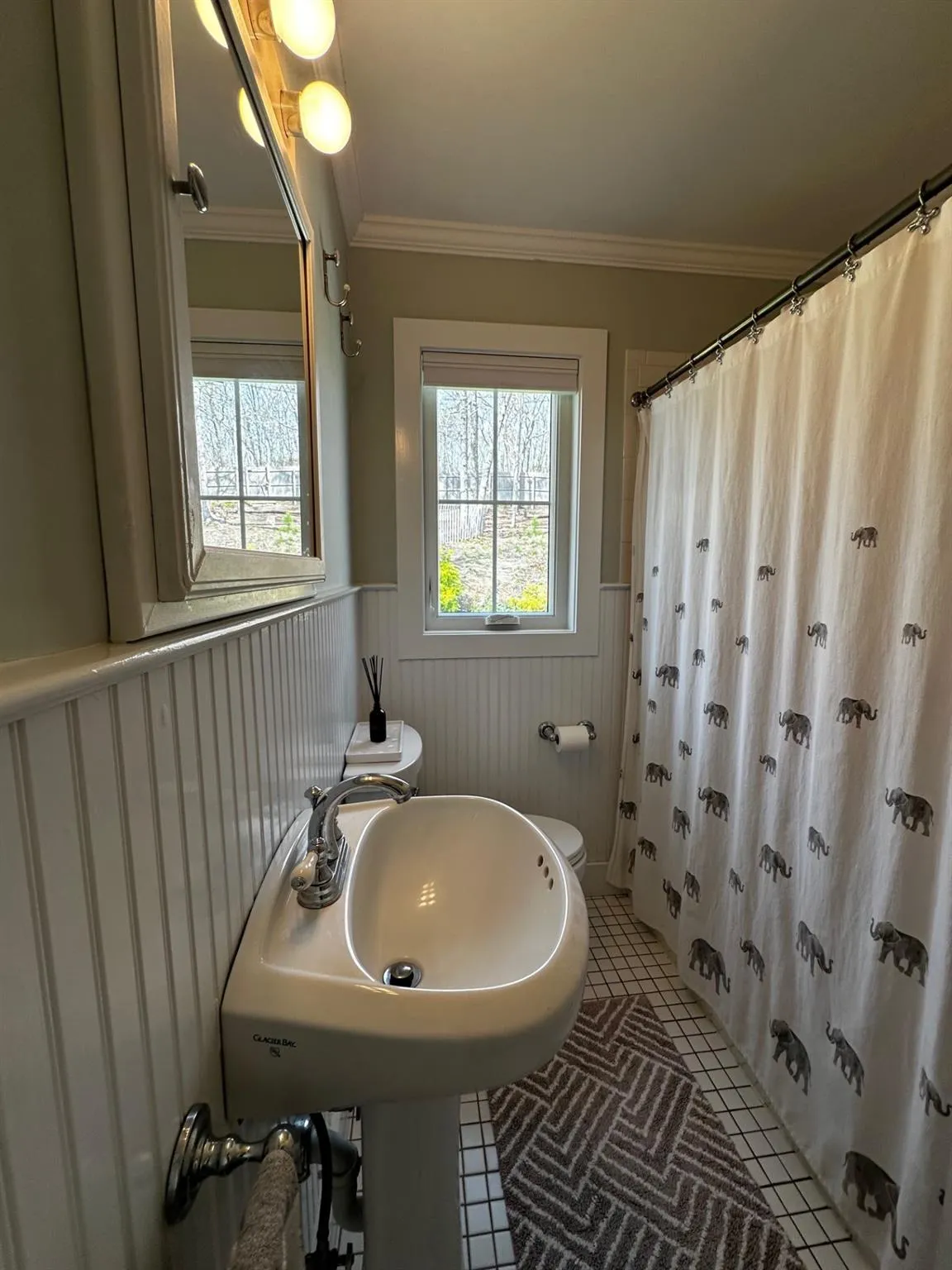Full bathroom with a wainscoted wall, toilet, ornamental molding, and a healthy amount of sunlight Full bathroom with a wainscoted wall, toilet, ornamental molding, and a healthy amount of sunlight