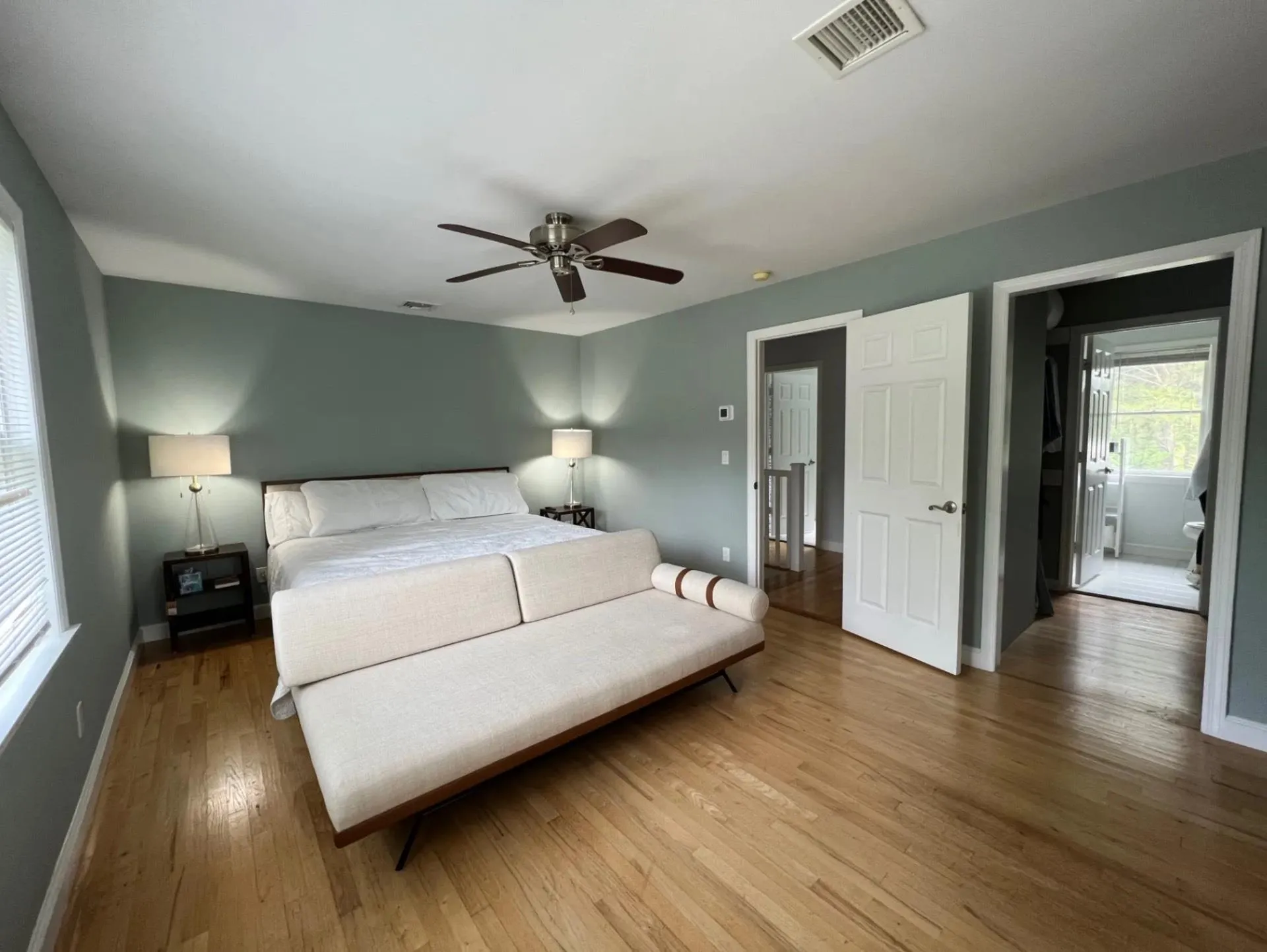 Bedroom featuring wood-type flooring, a ceiling fan, baseboards, and visible vents Bedroom featuring wood-type flooring, a ceiling fan, baseboards, and visible vents