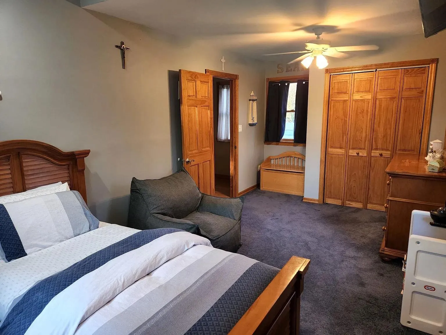 Bedroom featuring a ceiling fan, baseboards, and dark colored carpet Bedroom featuring a ceiling fan, baseboards, and dark colored carpet