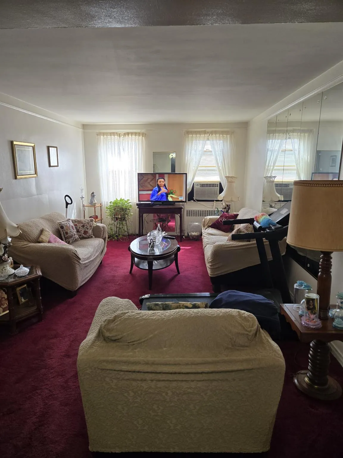 Carpeted living area featuring a wealth of natural light and cooling unit Carpeted living area featuring a wealth of natural light and cooling unit