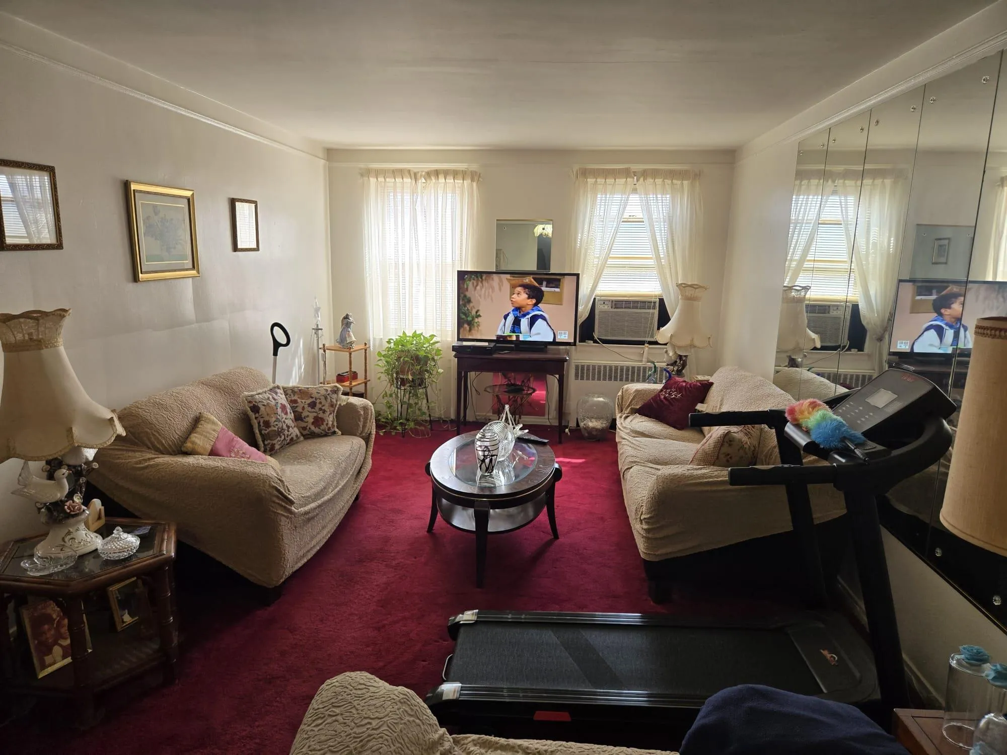 Living area featuring carpet floors, cooling unit, and radiator heating unit Living area featuring carpet floors, cooling unit, and radiator heating unit