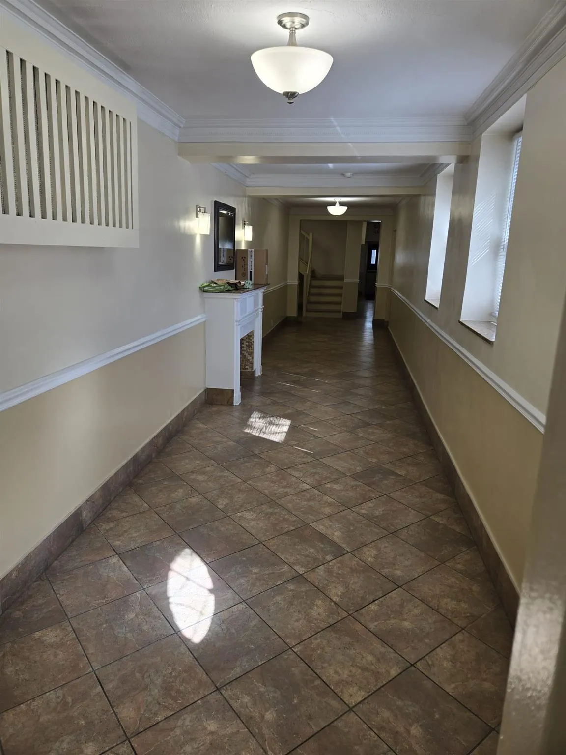 Hall with crown molding, baseboards, and stairs Hall with crown molding, baseboards, and stairs
