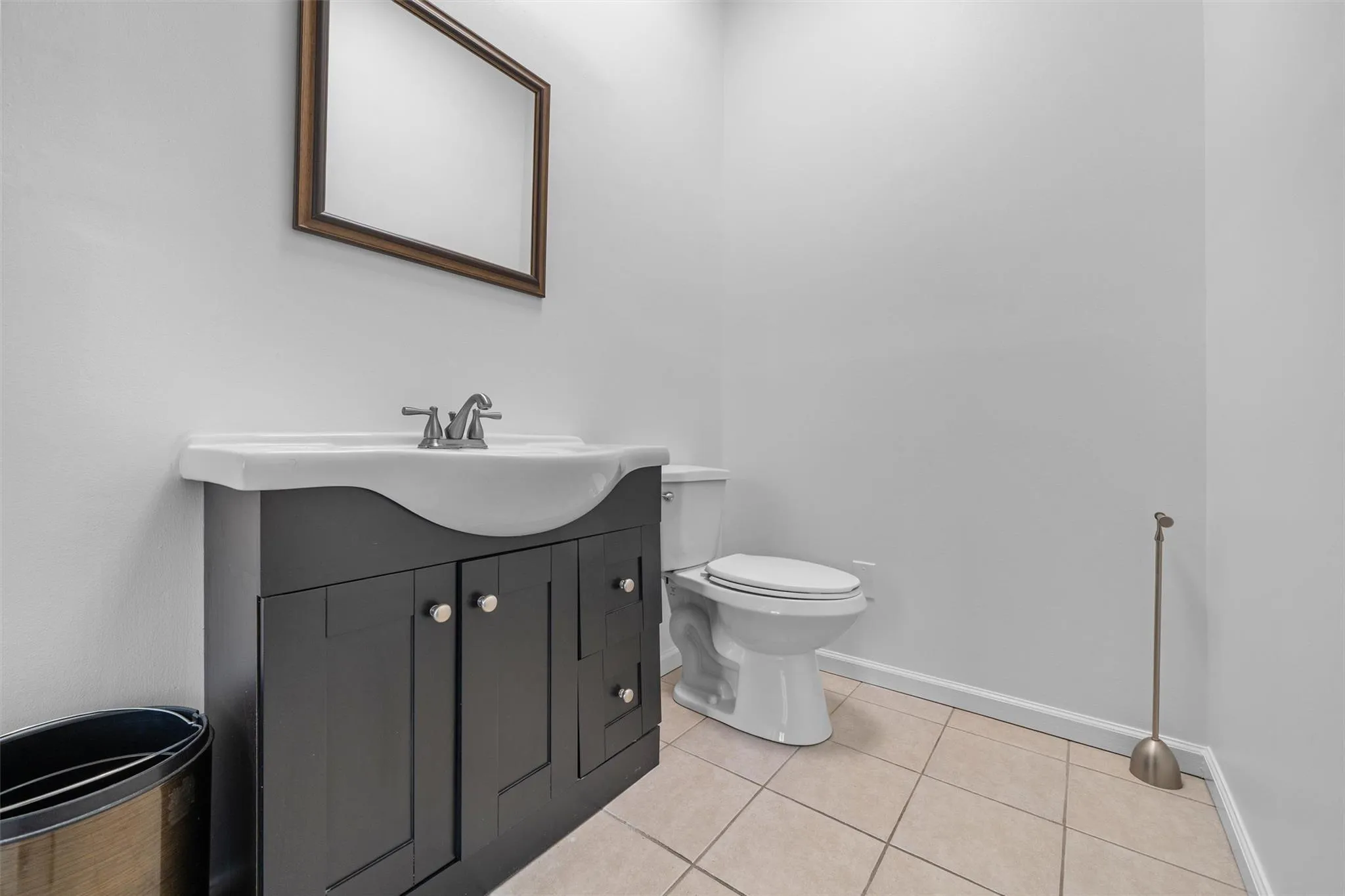 Bathroom featuring tile patterned floors, toilet, baseboards, and vanity Bathroom featuring tile patterned floors, toilet, baseboards, and vanity