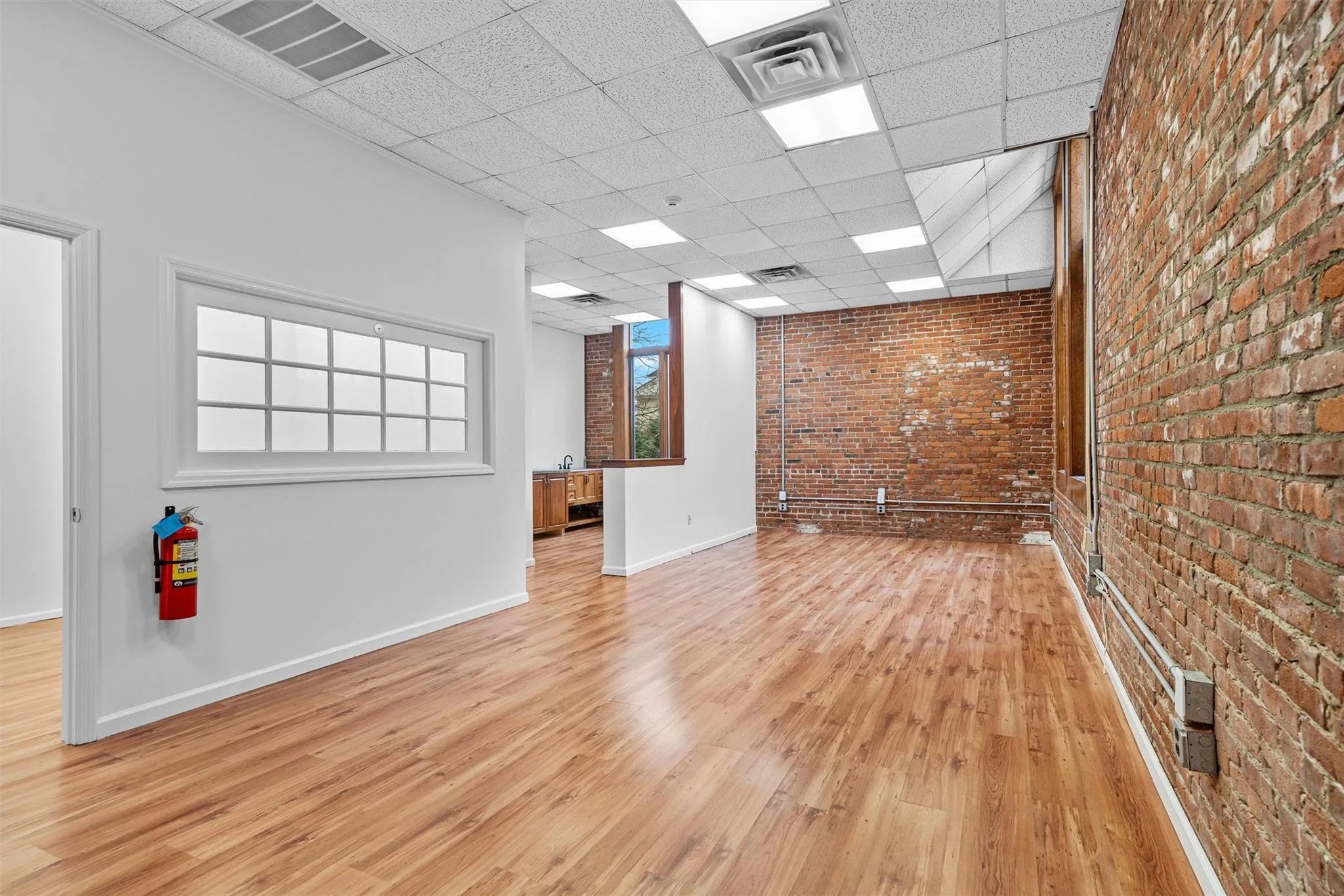Unfurnished room with a paneled ceiling, baseboards, light wood-style flooring, and visible vents Unfurnished room with a paneled ceiling, baseboards, light wood-style flooring, and visible vents