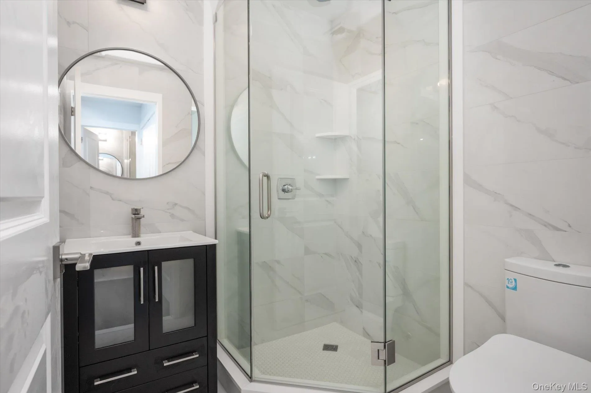 Gym bathroom with a stall shower, vanity, tile walls, and toilet Gym bathroom with a stall shower, vanity, tile walls, and toilet