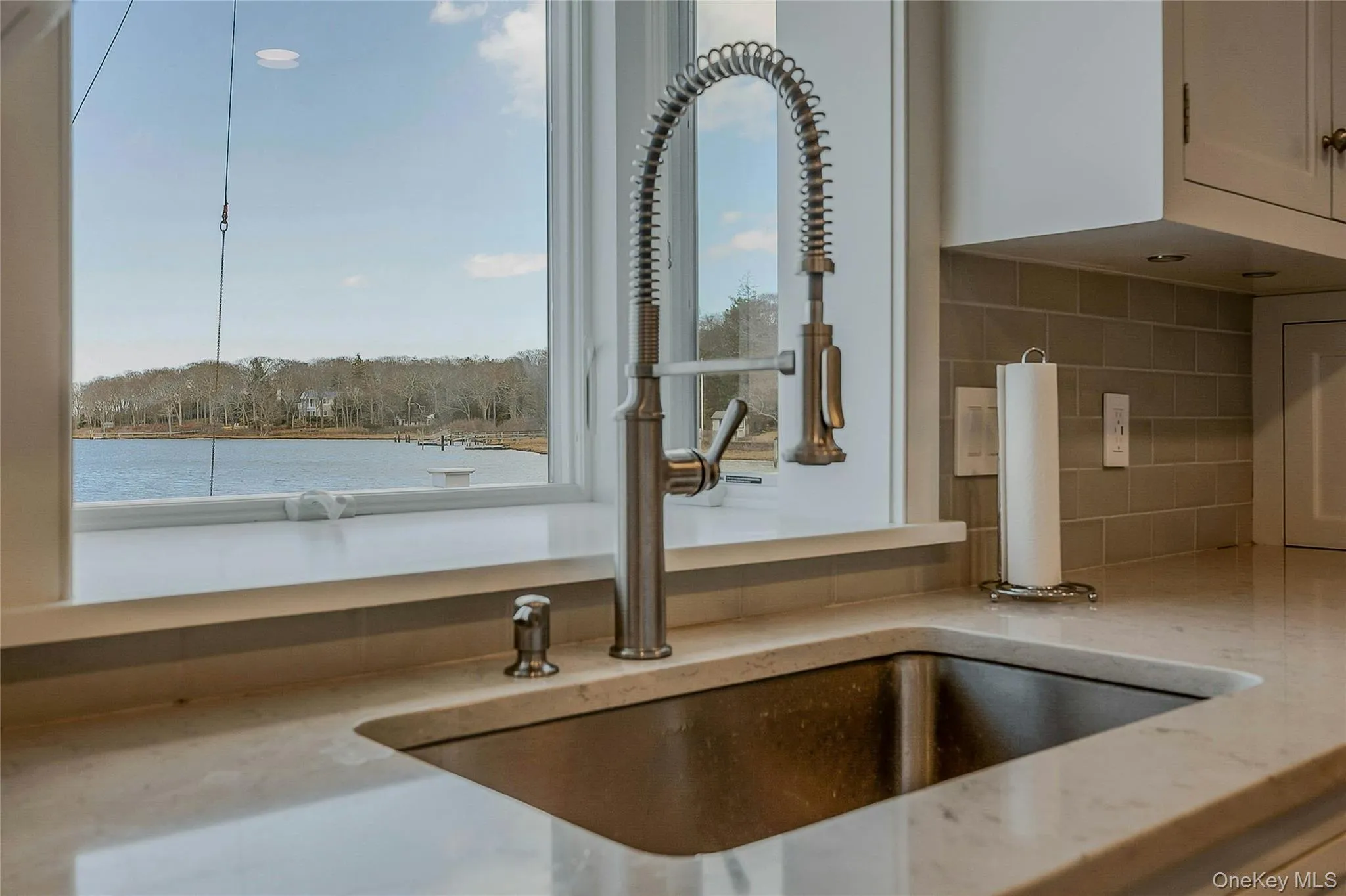 Details with a sink, backsplash, and light stone counters Details with a sink, backsplash, and light stone counters