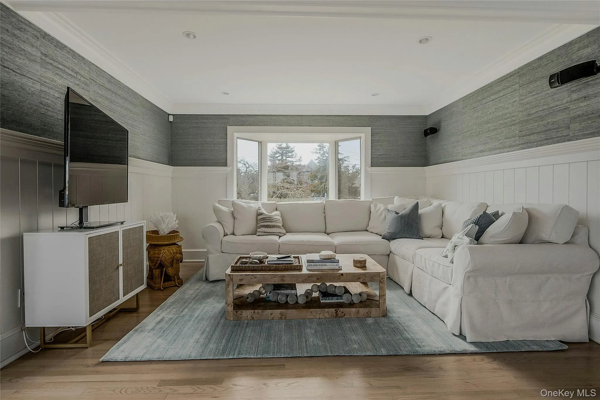 Living room with wainscoting, crown molding, and wood finished floors Living room with wainscoting, crown molding, and wood finished floors