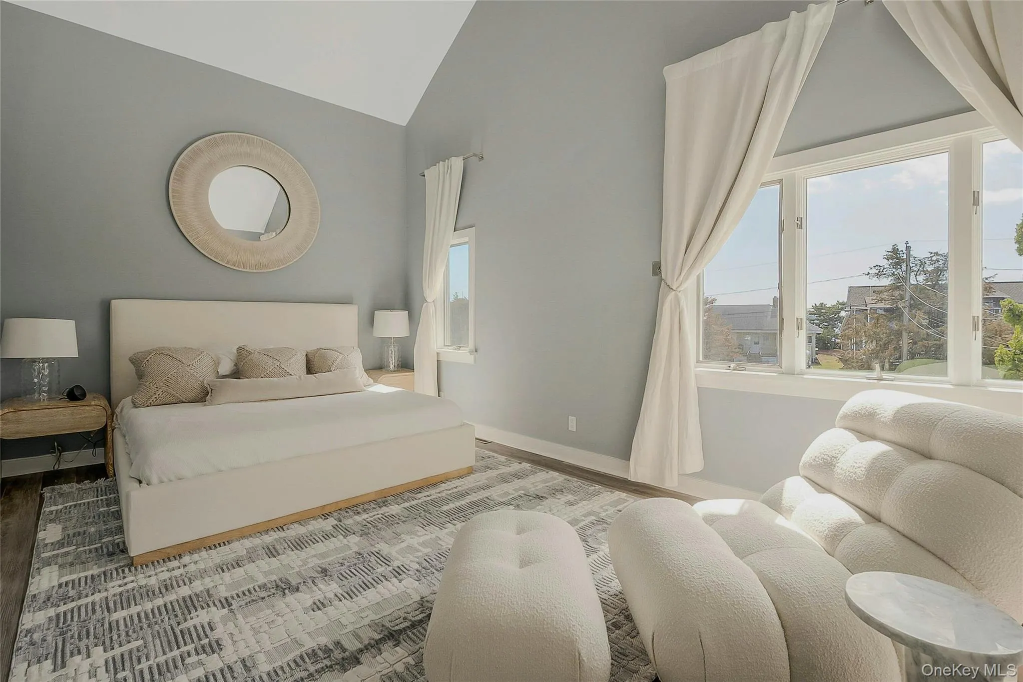 Bedroom with high vaulted ceiling, baseboards, multiple windows, and wood finished floors Bedroom with high vaulted ceiling, baseboards, multiple windows, and wood finished floors