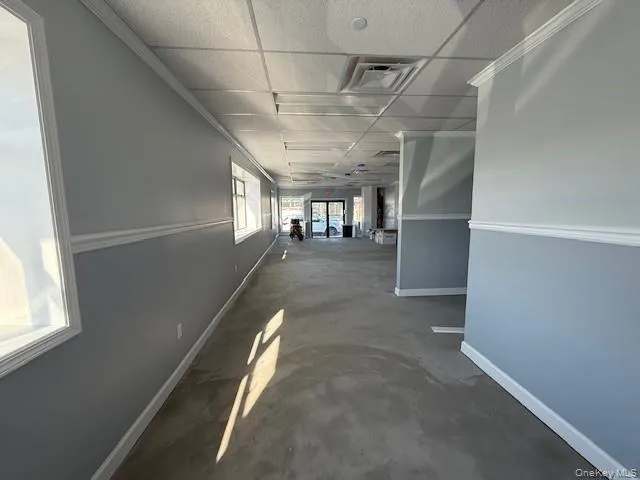 Hall featuring baseboards, visible vents, a drop ceiling, and Plank Flooring to be installed Hall featuring baseboards, visible vents, a drop ceiling, and Plank Flooring to be installed