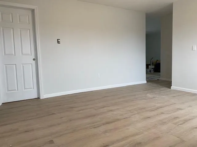 Spare room featuring baseboards and wood finished floors Spare room featuring baseboards and wood finished floors