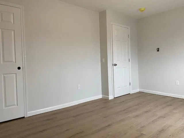 Empty room with baseboards and wood finished floors Empty room with baseboards and wood finished floors