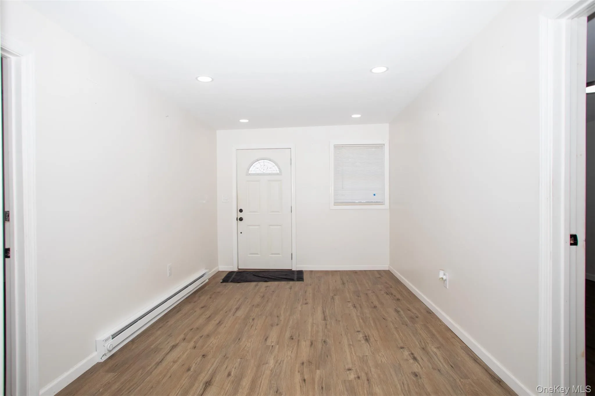 Entrance foyer featuring a baseboard radiator, baseboards, light wood finished floors, and recessed lighting Entrance foyer featuring a baseboard radiator, baseboards, light wood finished floors, and recessed lighting
