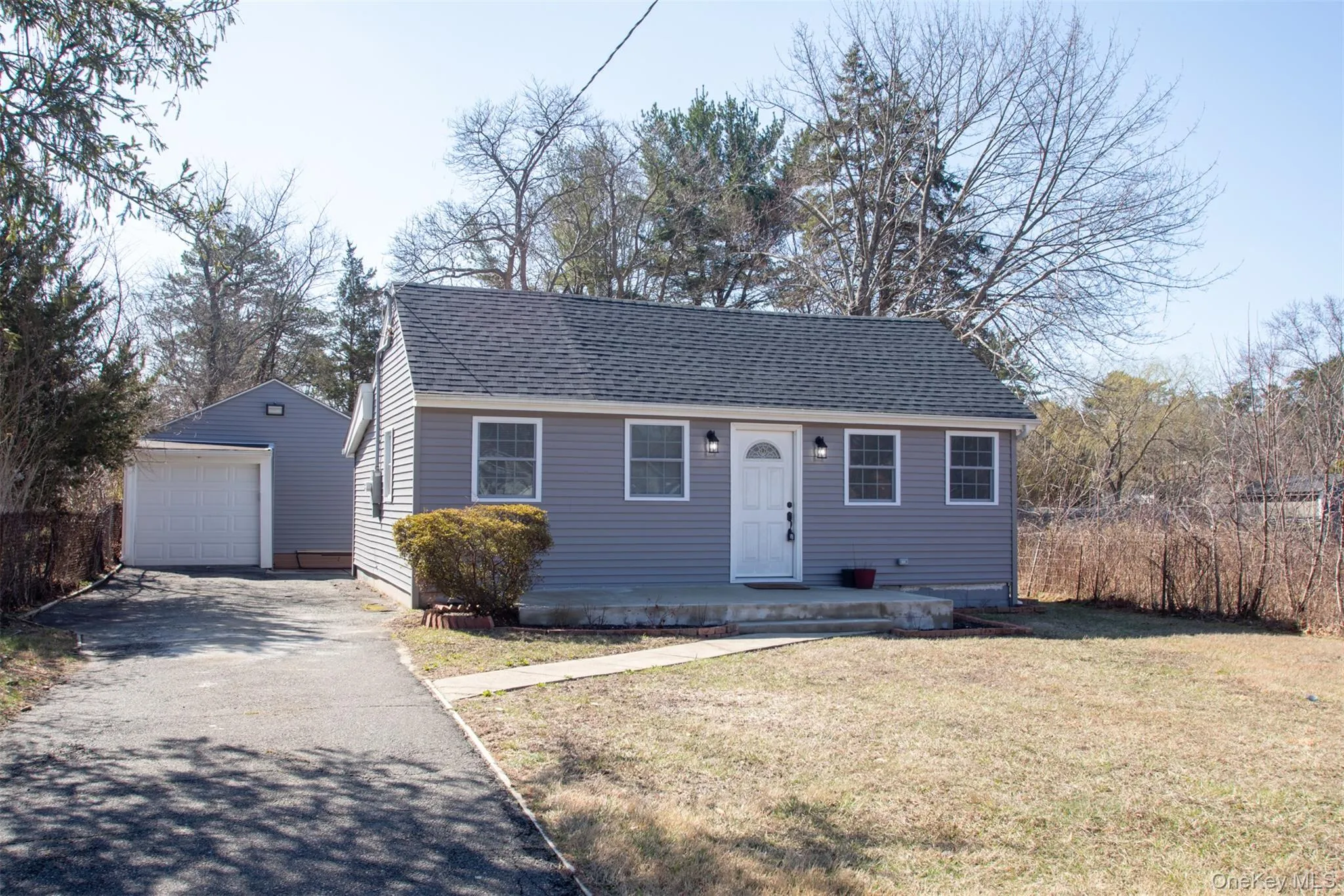 Bungalow with driveway, a front yard, an outdoor structure, a shingled roof, and a garage Bungalow with driveway, a front yard, an outdoor structure, a shingled roof, and a garage