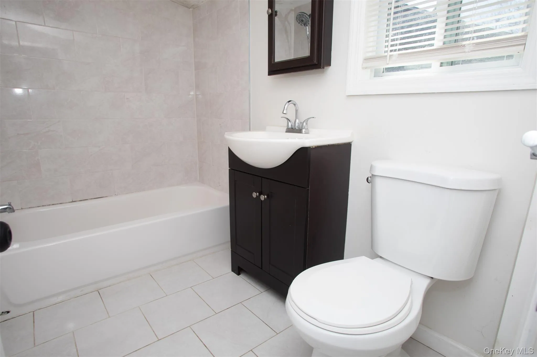 Bathroom with shower combination, toilet, tile patterned floors, and vanity Bathroom with shower combination, toilet, tile patterned floors, and vanity