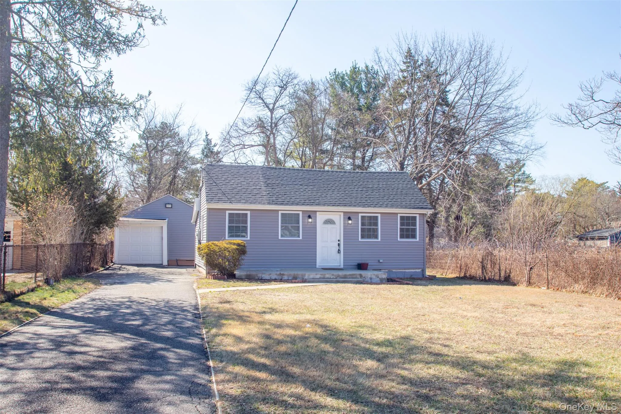 View of front of property with driveway, a front yard, an outbuilding, fence, and a detached garage View of front of property with driveway, a front yard, an outbuilding, fence, and a detached garage
