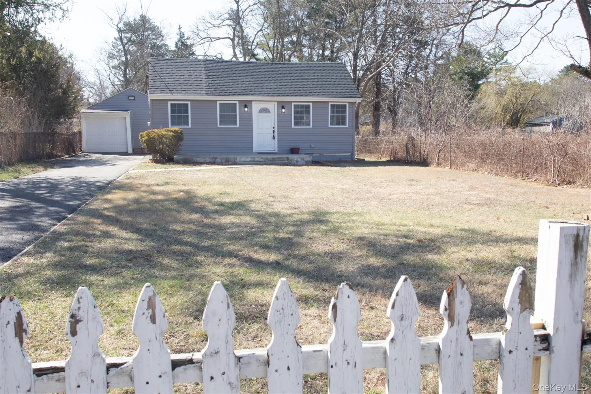 View of front of home with fence, a garage, a front yard, roof with shingles, and driveway View of front of home with fence, a garage, a front yard, roof with shingles, and driveway