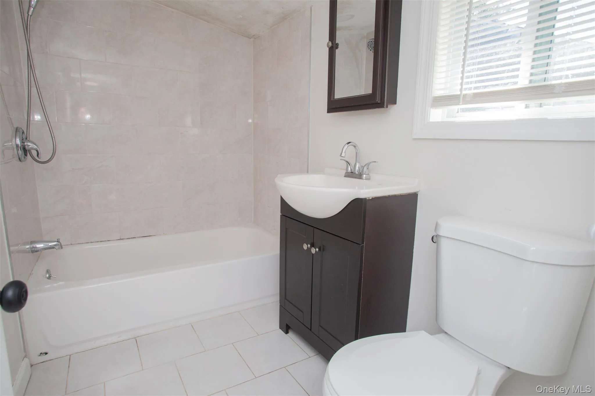 Full bathroom with tub / shower combination, toilet, tile patterned flooring, and vanity Full bathroom with tub / shower combination, toilet, tile patterned flooring, and vanity