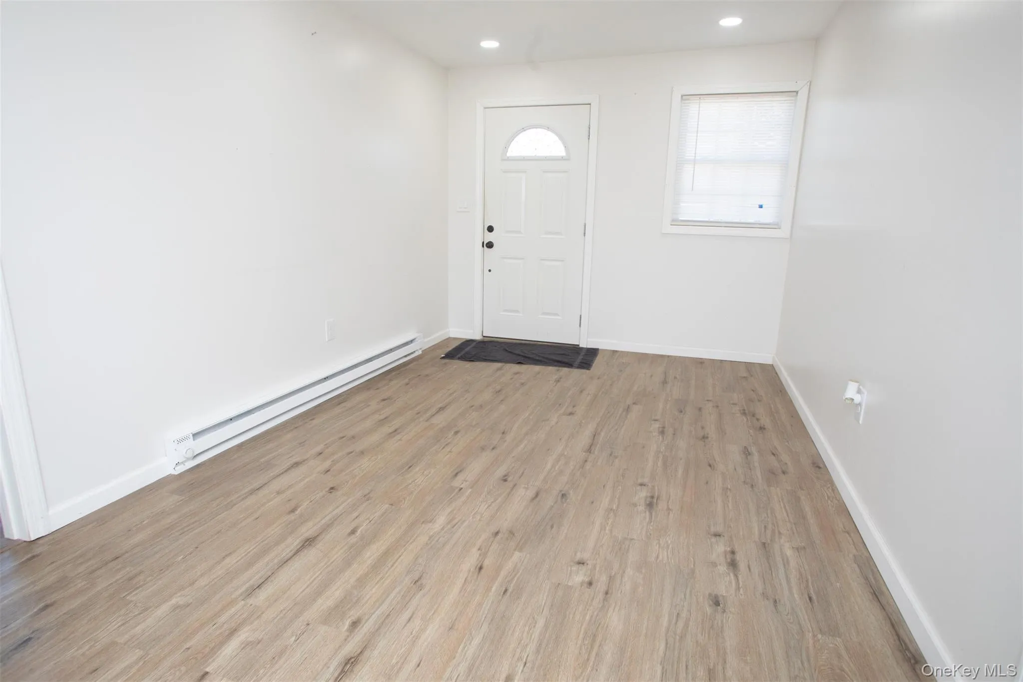 Foyer entrance featuring baseboards, light wood-type flooring, a baseboard heating unit, and recessed lighting Foyer entrance featuring baseboards, light wood-type flooring, a baseboard heating unit, and recessed lighting